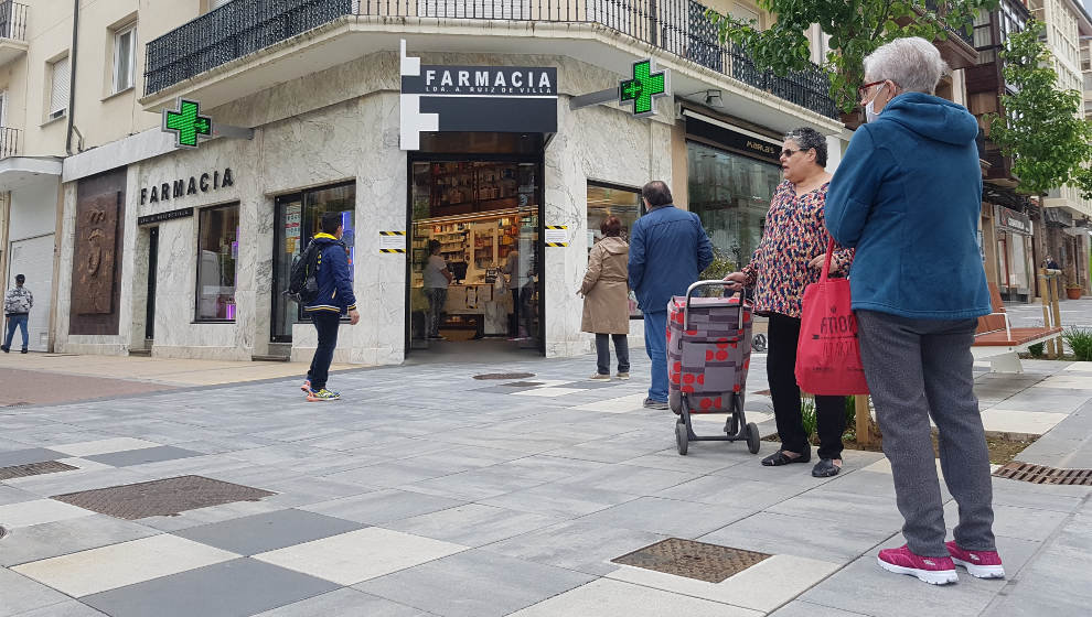 Vecinos de Torrelavega haciendo cola frente a una farmacia