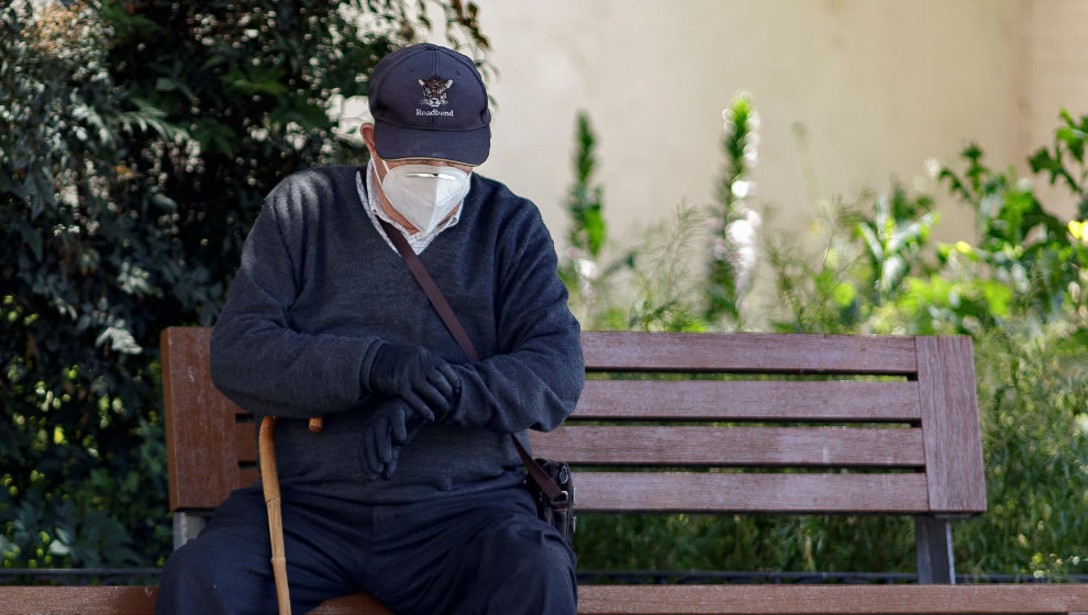 Un hombre por la calle protegido con mascarilla