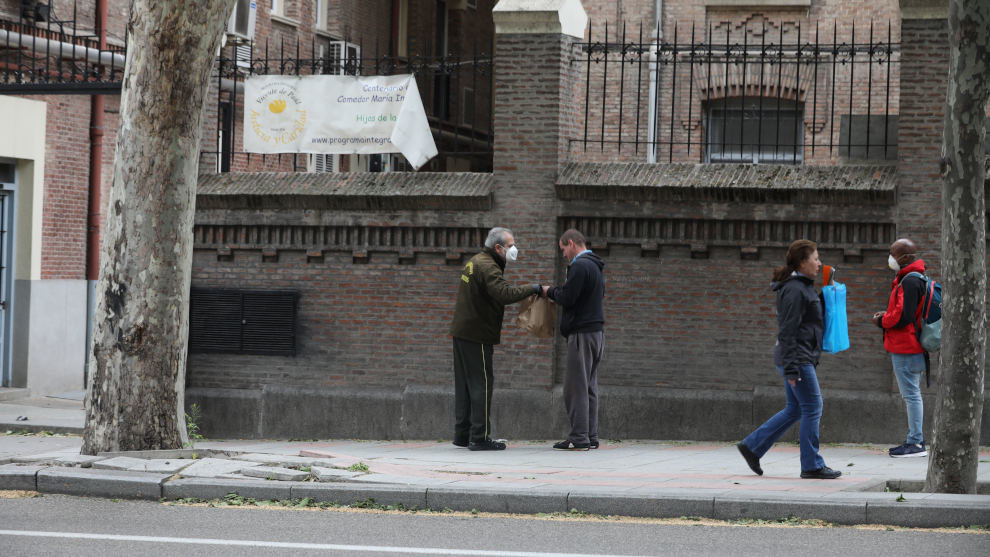 Varias personas esperan en cola para entrar en el comedor de las Hijas de la Caridad de San Vicente de Paúl en el madrileño barrio de Chamberí