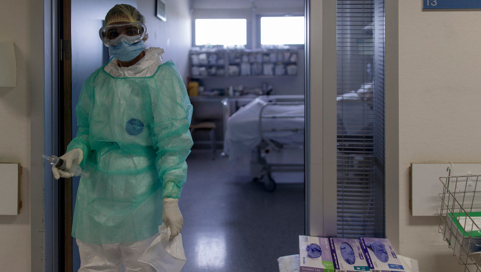Un trabajador sanitario en la puerta de la habitación de un paciente ingresado en la Unidad de Cuidados Intensivos del Hospital Infanta Sofía en San Sebastián de los Reyes (Madrid)