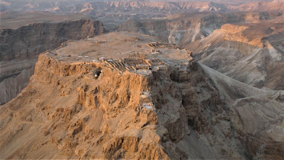 MESETA DE MASADA, CON LA FORTIFICACIÓN EN SU CIMA Y EL PALACIO COLGANTE DE HERODES DEBAJO DE AQUELLA. A LA DERECHA, LA RAMPA DE ASALTO  ROMANA, Wkipedia