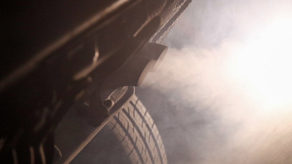 Tubo de escape de un coche emitiendo polución