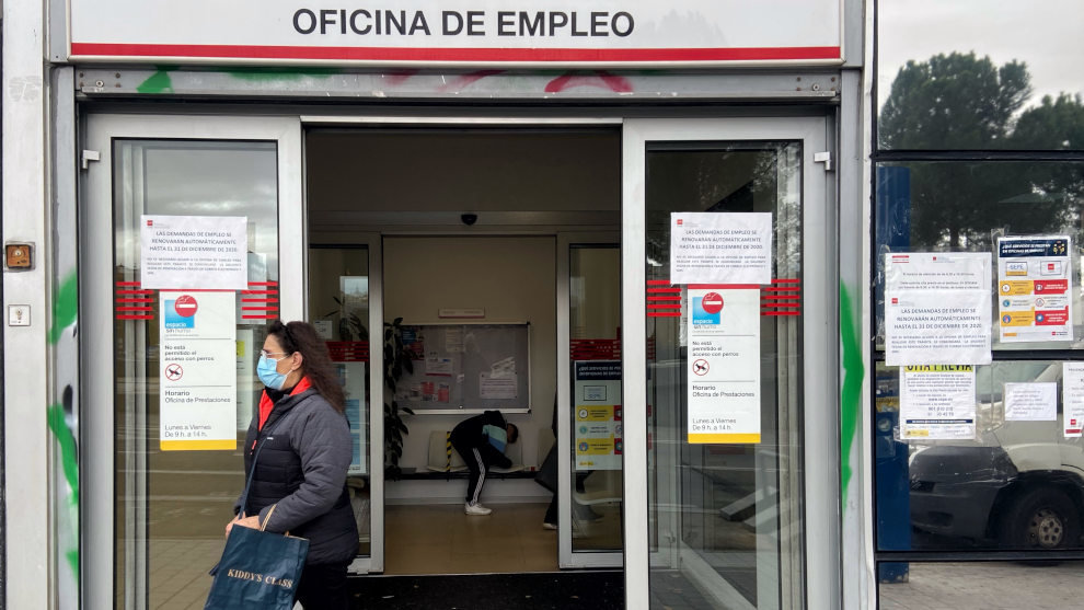 Una mujer sale de una oficina de empleo