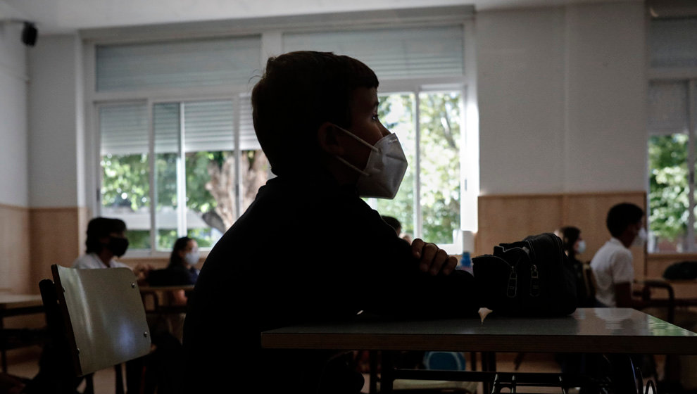 Un niño con mascarilla en un aula