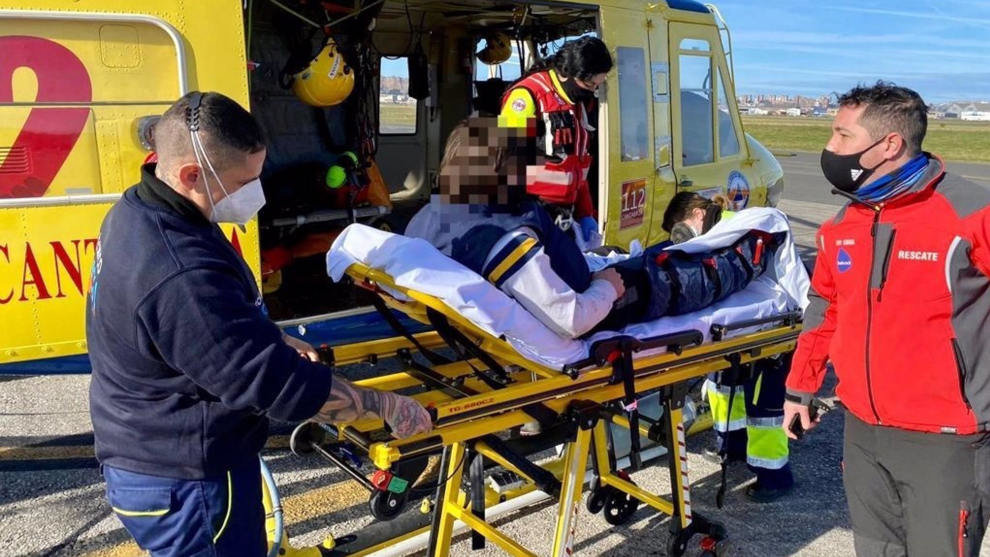 El joven lesionado en una pierna tras sufrir una caída en Ruente es introducido en el helicóptero del Gobierno de Cantabria