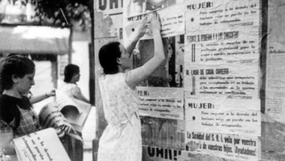 Mujeres pegando propaganda