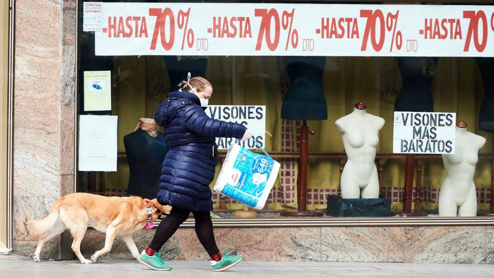 Mujer junto a un comercio cerrado