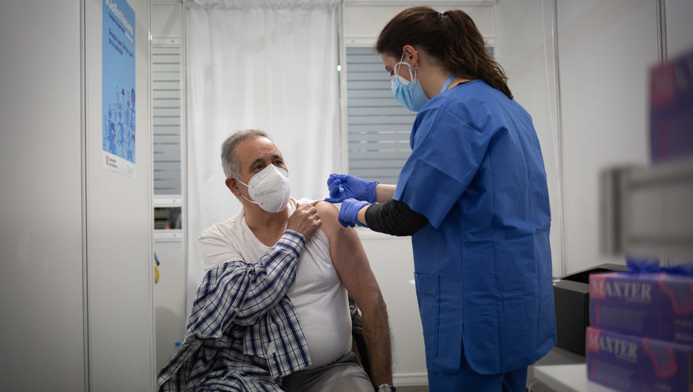 Una sanitaria vacuna a un hombre