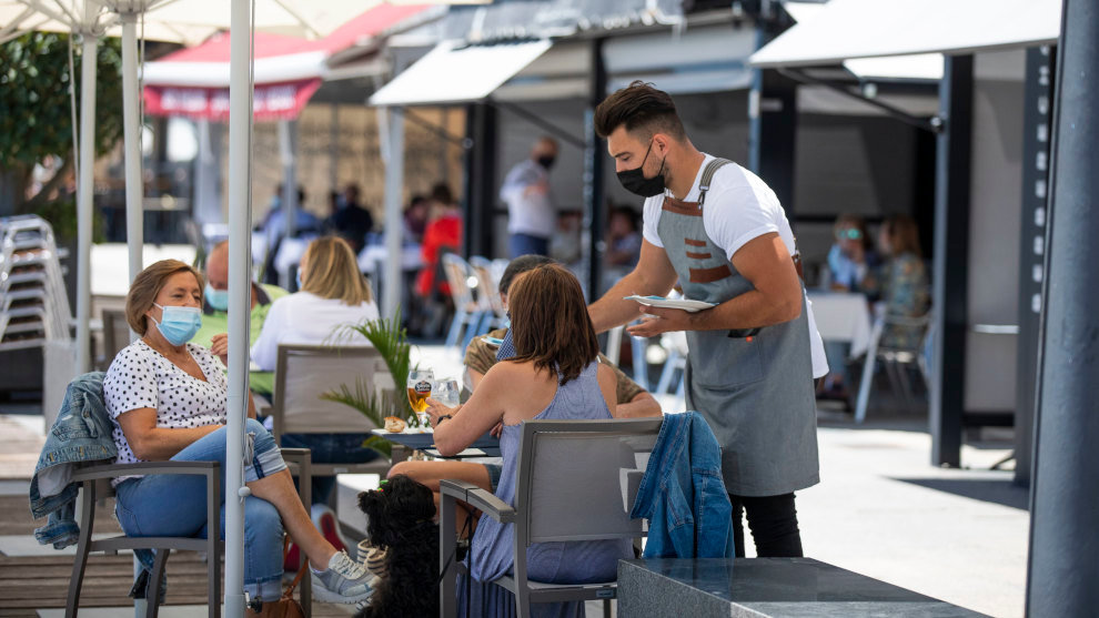 Varias personas con mascarilla en una terraza