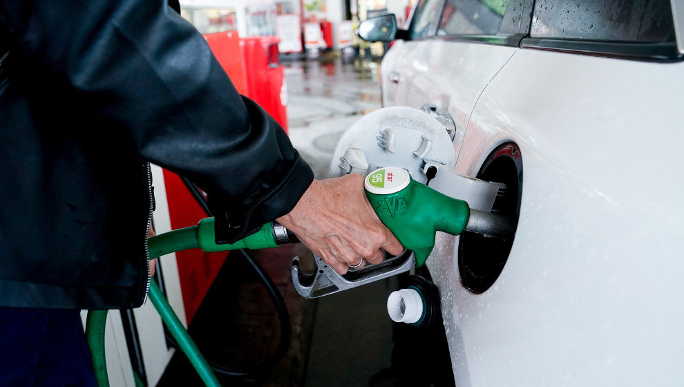 Una mujer pone gasolina a su vehículo en una estación de servicio