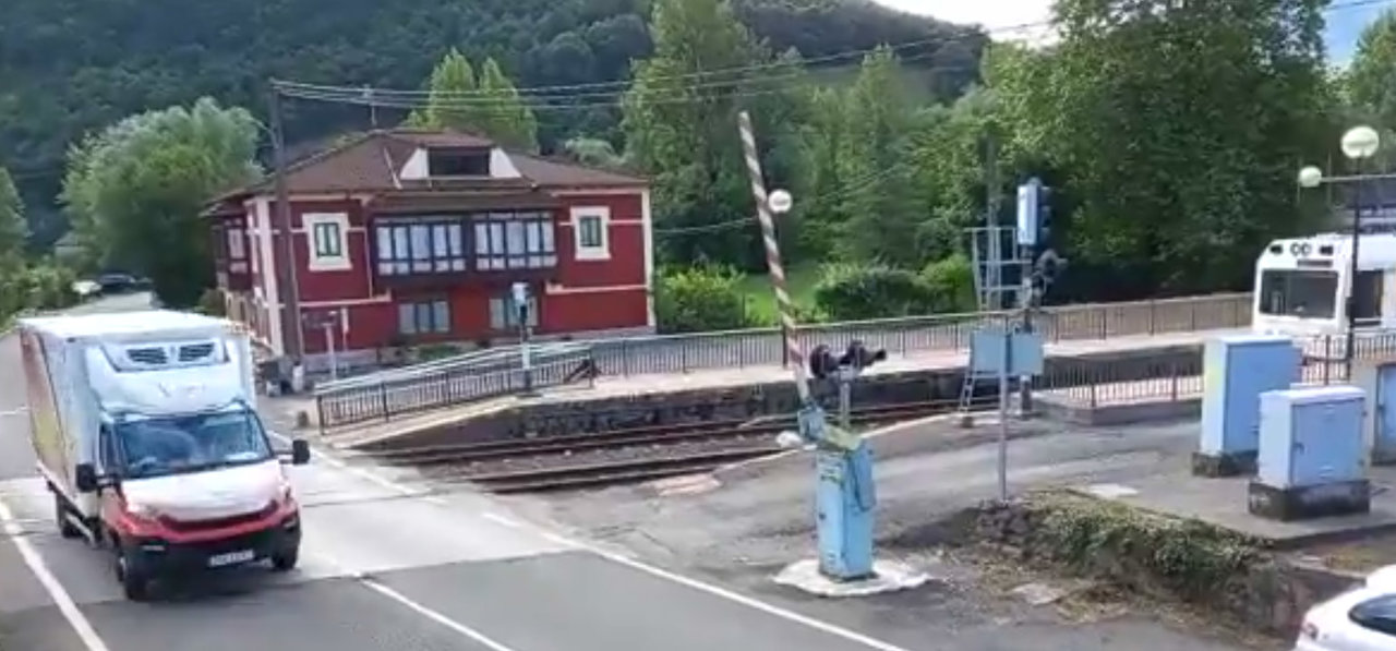 Instante en el que la furgoneta atraviesa las vías con el tren en marcha