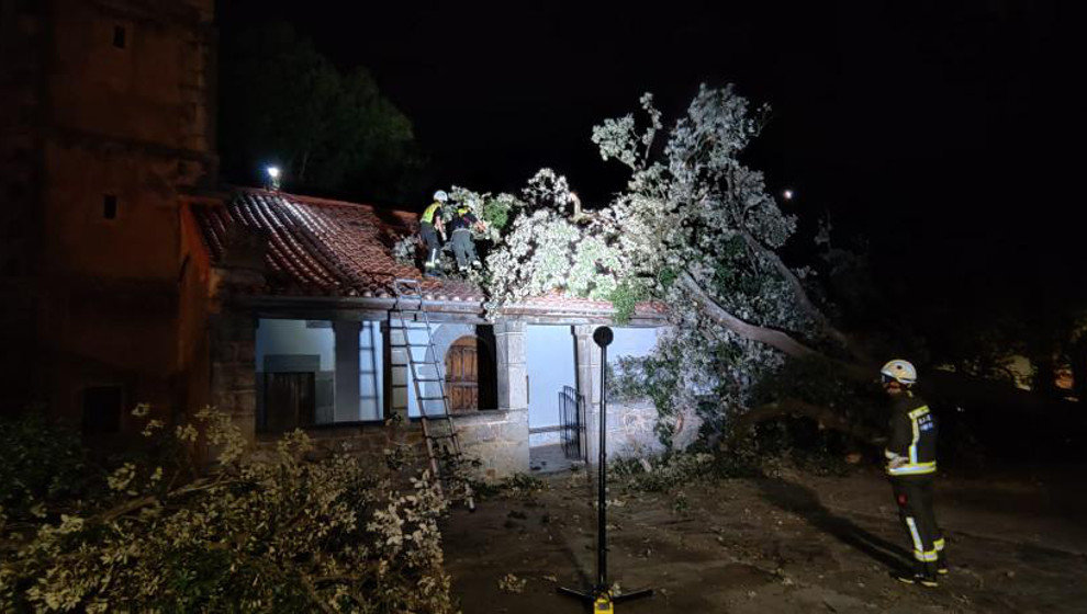 Árbol caído sobre el tejado de la iglesia de Bustablado | Foto: 112 Cantabria