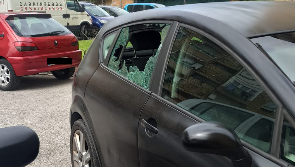 Imagen de un coche con el cristal roto en una urbanización de Sierrapando