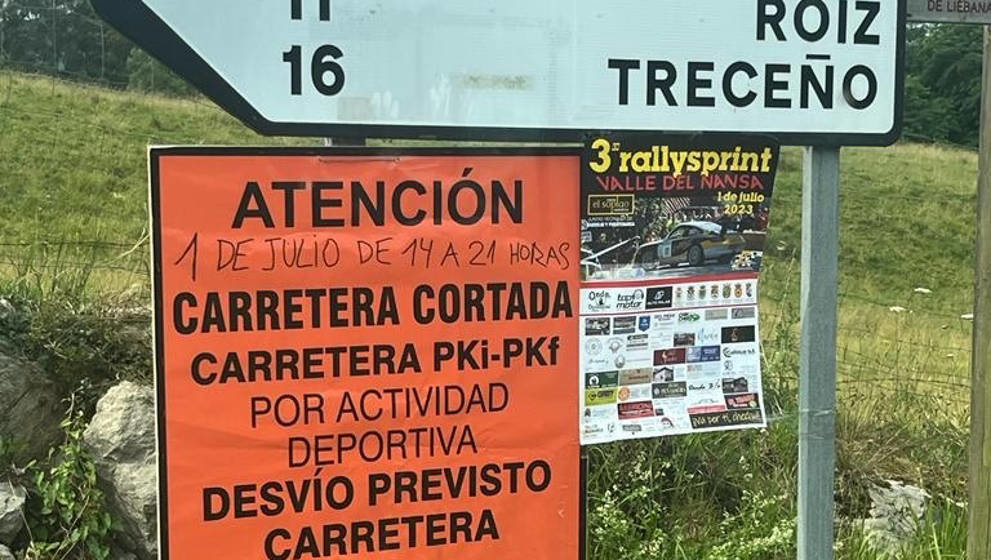 Señales de tráfico con un cartel de aviso sobre el rallye