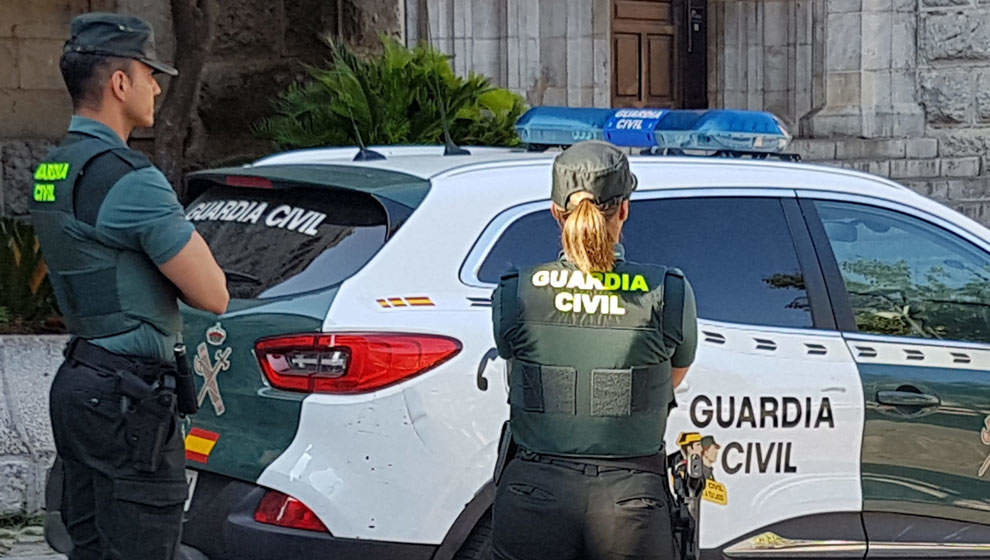 Dos agentes de la Guardia Civil junto a un vehículo del cuerpo