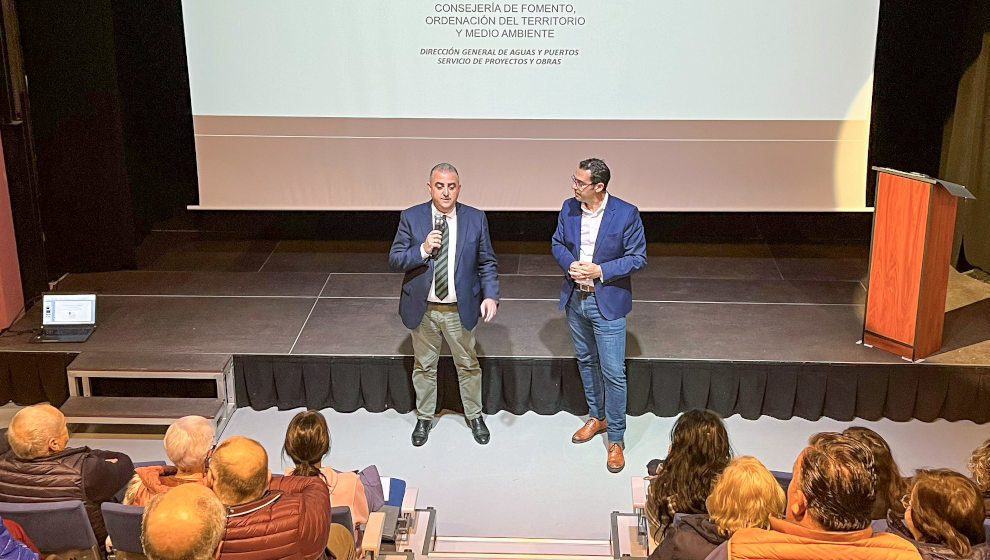 El consejero de Fomento, Roberto Media, y el alcalde, Roberto Escobedo durante la presentación del proyecto a los vecinos de Molleda en el auditorio de Unquera