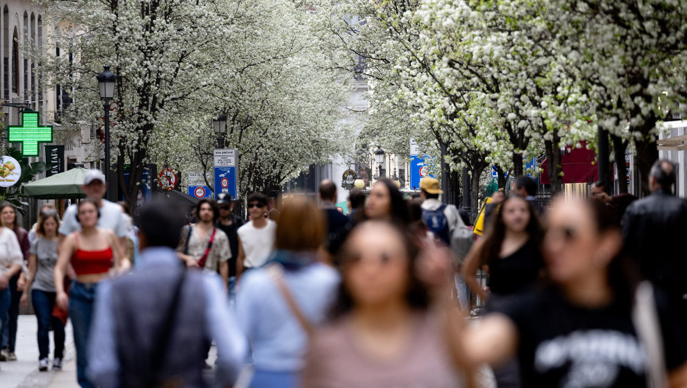 Varias personas pasean junto a árboles en flor durante el primer día de primavera