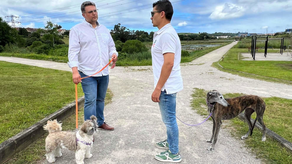 Dos perros con sus propietarios de paseo por Astillero