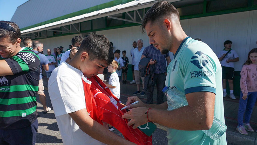 Jugadores firmando autógrafos a aficionados apostados a la entrada del entrenamiento