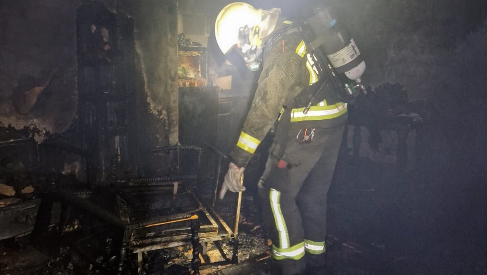  Un bombero trabaja en el incendio de una vivienda