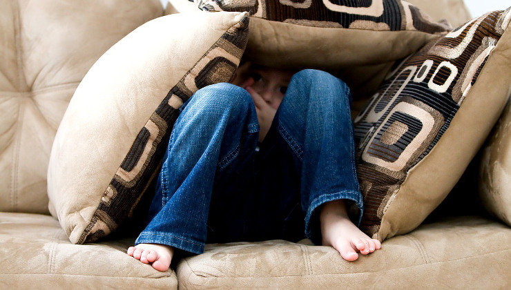 Un niño se esconde entre los cojines. Foto: Pixabay