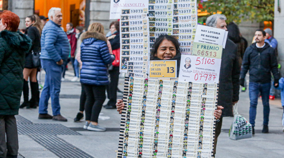 Una mujer vende décimos de Lotería de Navidad de la Administración de Doña Manolita, en Madrid (España)