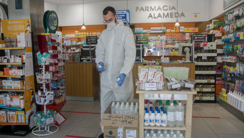 Un farmacéutico atiende una farmacia con equipo de protección