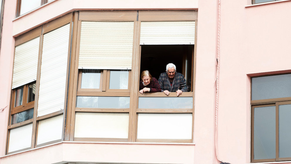 Unos ancianos confinados en sus casas se asoman a su ventana