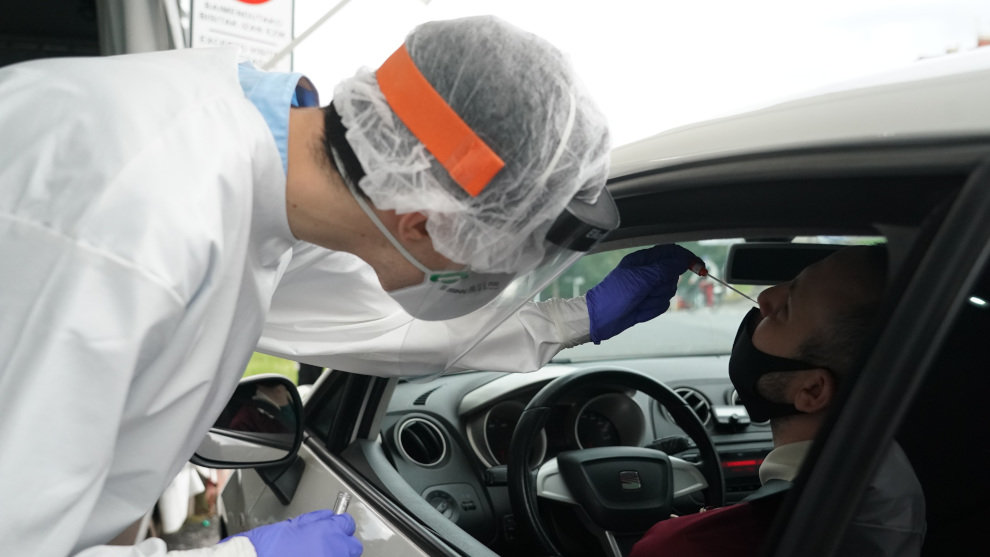 Un trabajador sanitario le realiza un test desde un vehículo a un hombre