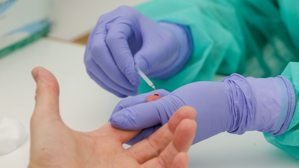 Una trabajadora sanitaria totalmente protegida realiza una prueba diagnóstica del coronavirus
