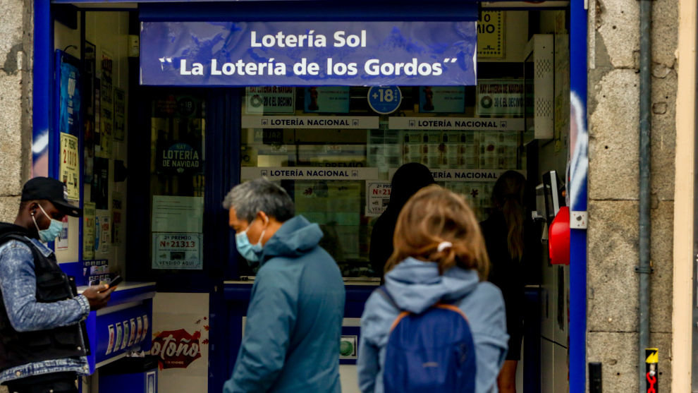 Varias personas hacen cola en las inmediaciones de la administración de lotería Sol