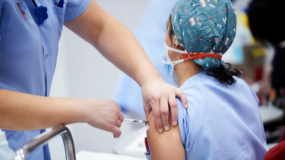 Un trabajadora sanitaria inyecta la segunda dosis de la vacuna de Pfizer-BioNTech contra la Covid-19 a una sanitaria del Hospital Universitario Marqués de Valdecilla
