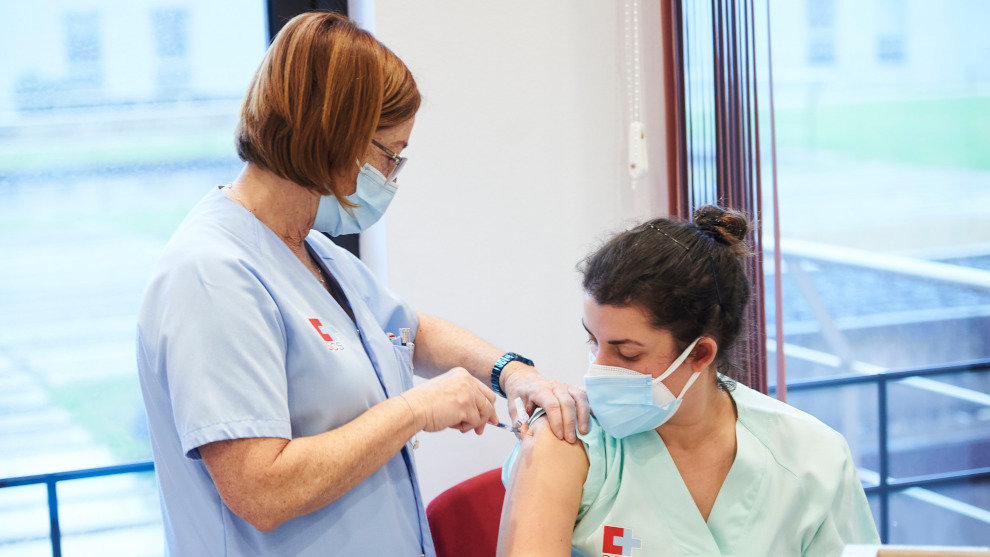 Una trabajadora sanitaria inyecta la segunda dosis de la vacuna de Pfizer-BioNTech contra la Covid-19 a una sanitaria del Hospital Universitario Marqués de Valdecilla