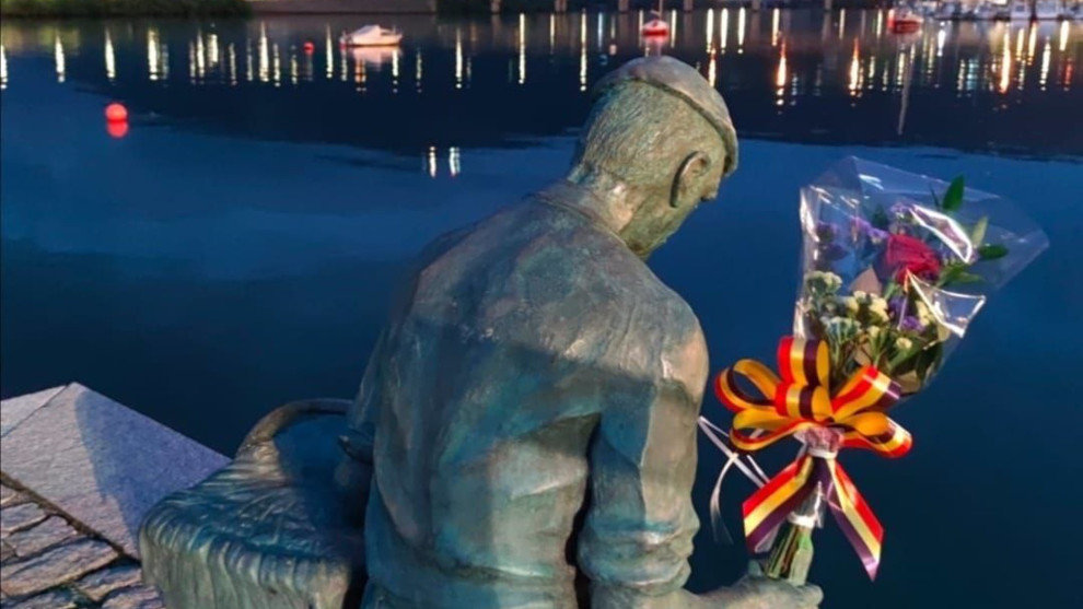 Estatua del pescador en el muelle e Astillero con flores por las víctimas en accidentes laborales 