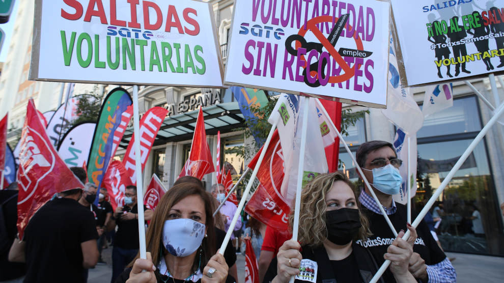 Varios trabajadores de CaixaBank con pancartas durante el paro parcial convocado para protestar por el ERE de la entidad financiera, a 7 de junio de 2021, en Madrid,