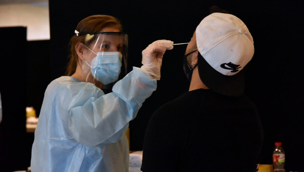 Una trabajadora sanitaria realiza un test de antígenos a un joven