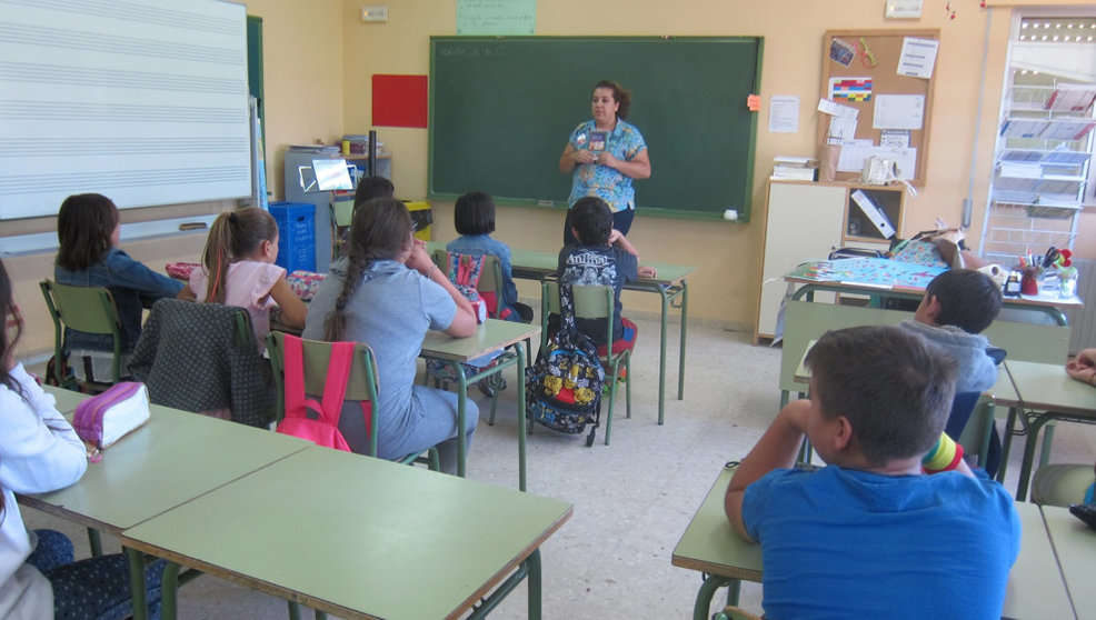 Alumnos escuchando a su profesora en el aula de un colegio