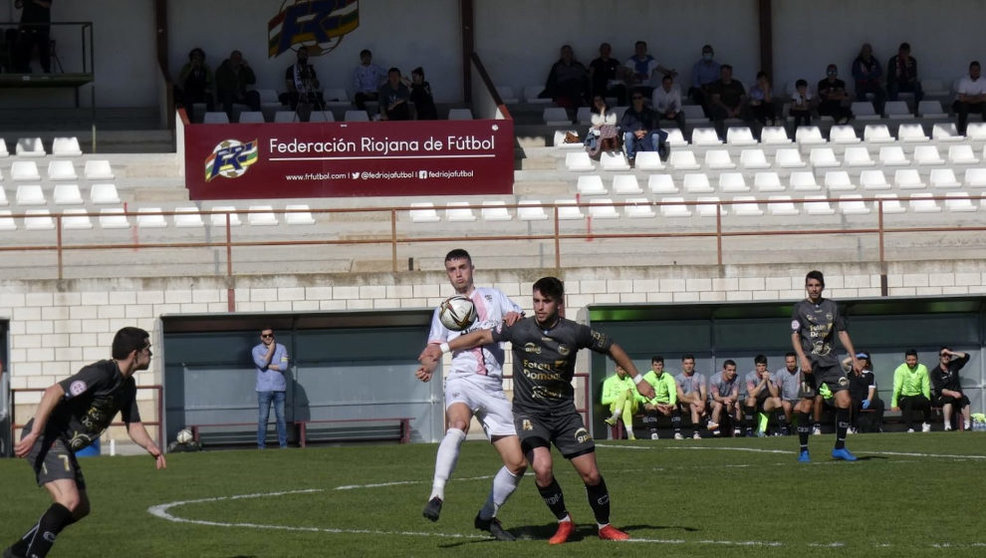 Disputa de balón entre un futbolista del CD Laredo y el Racing Rioja CF