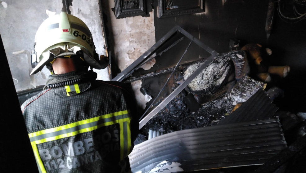 Los bomberos en el incendio del piso de Los Corrales de Buelna