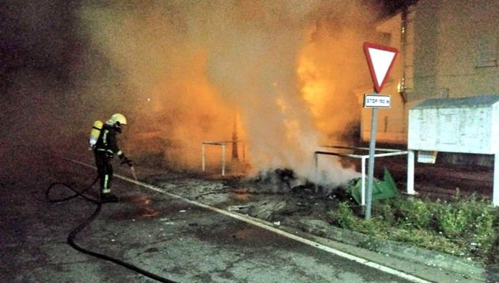 Los bomberos apagan las llamas de los contenedores quemados. Foto: Twitter 112 Cantabria
