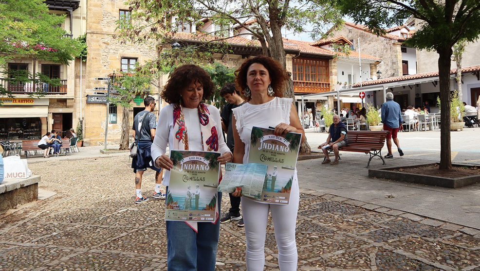 La alcaldesa de Comillas, Teresa Noceda, (izda) y la concejala Vanesa Sánchez con el cartel del Día del Indiano
