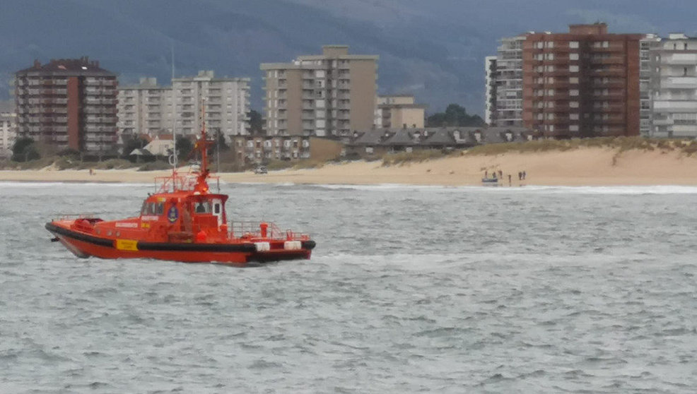 Dispositivo de búsqueda del hombre desaparecido con el barco volcado al fondo en la orilla | Foto: Agustín Martínez