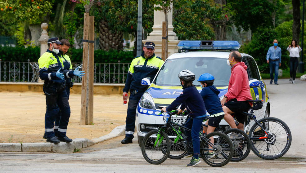 La policía local explica a un padre y sus hijos las normas para poder salir