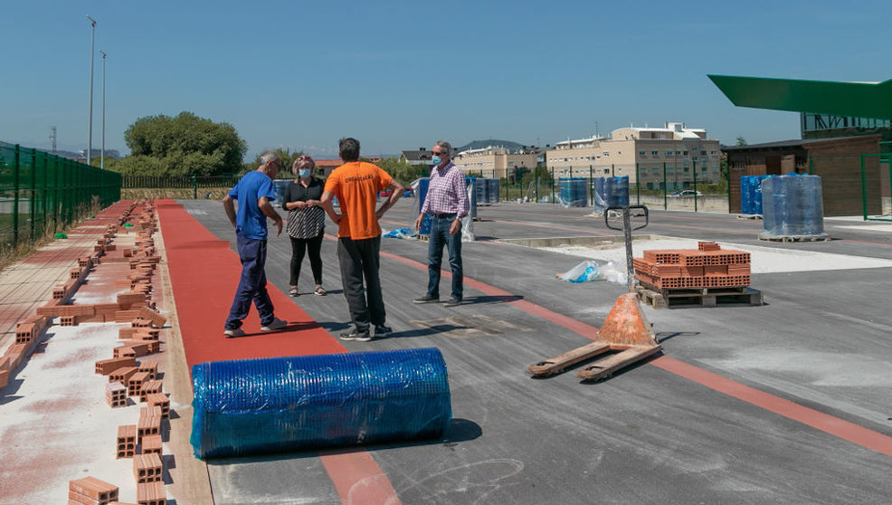 Trabajos de colocación del pavimento de la nueva pista de atletismo en Requejada