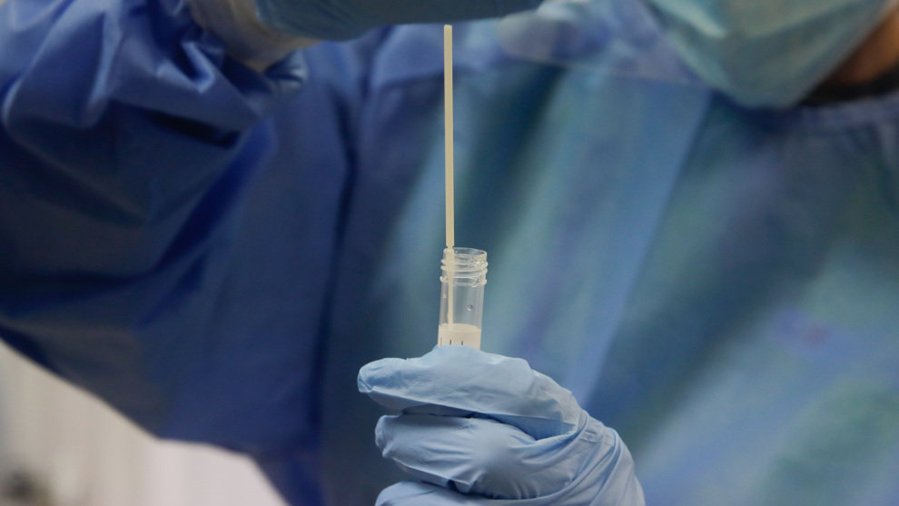 Una trabajadora sanitaria sostiene una probeta con una prueba PCR en el dispositivo instalado en el Centro de Especialidades El Arroyo, en Fuenlabrada, Madrid