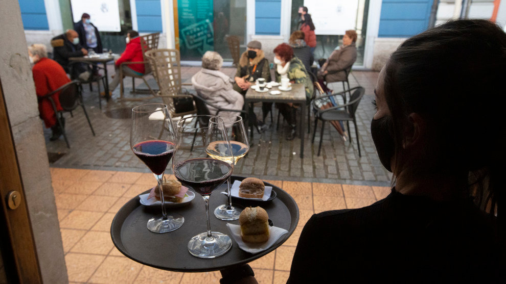 Una camarera se dispone a servir en una terraza de un restaurante