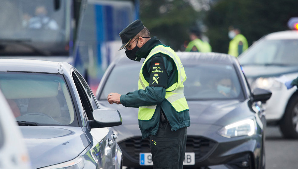 Un agente de la Guardia Civil pide la documentación a un vehículo durante un control efectuado en Laredo, Cantabria