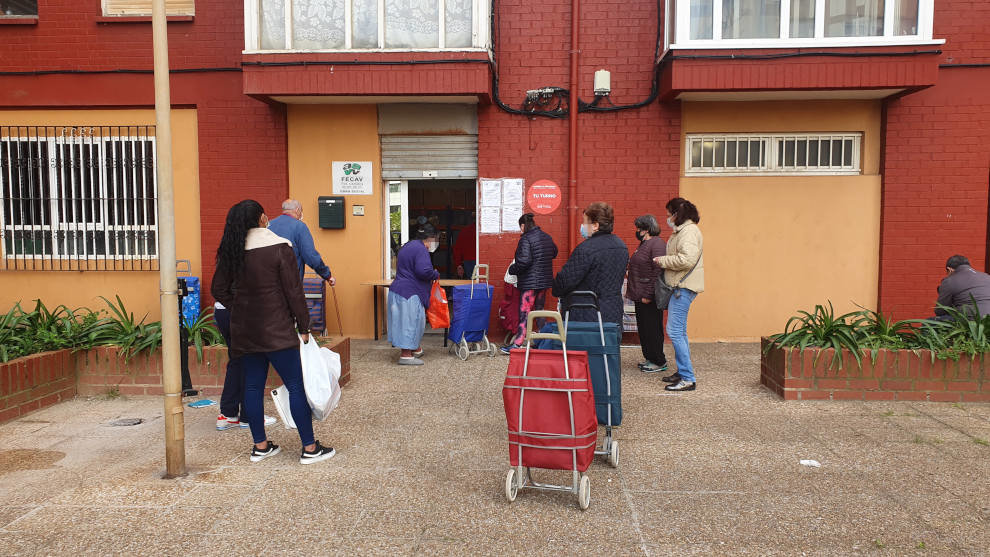 Cola de personas esperando a recibir los alimentos en el almacén de la Fecav en Santander