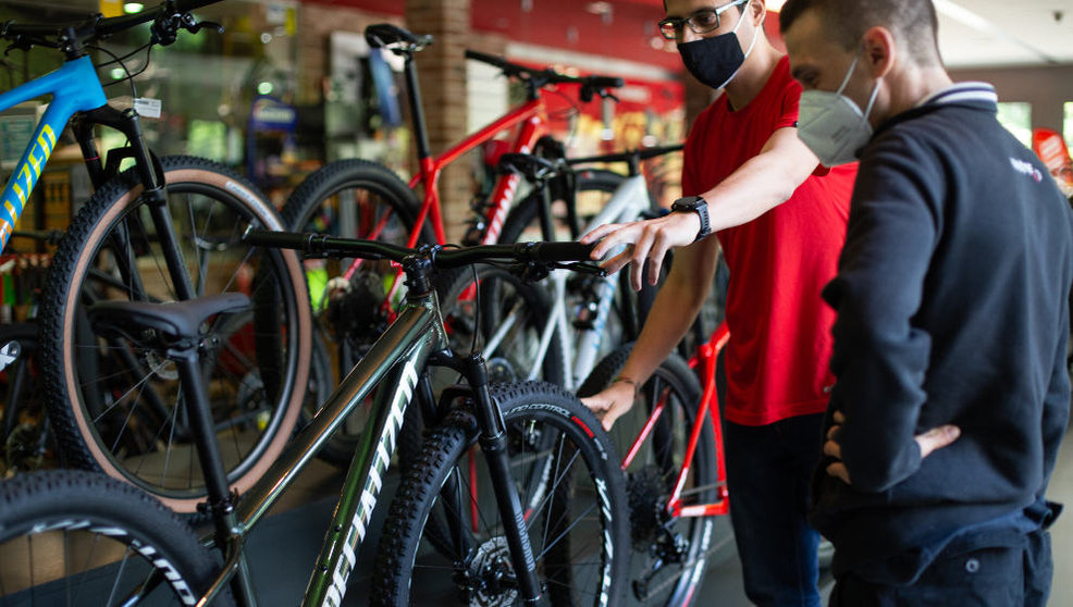 Un trabajador de una tienda le enseña a un cliente una de las bicicletas