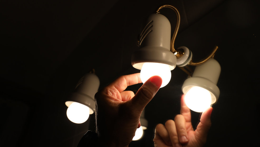 Una persona cambia la bombilla de una lámpara